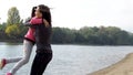 Mom and daughter on the river bank. Mom hugs her daughter at the river. The family is hugging. T