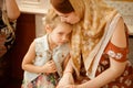 Mom and daughter sit on bench in Church Orthodox