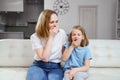 Mom and daughter are sitting on the couch, they both yawn and want to sleep. Royalty Free Stock Photo