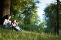 Mom and daughter are sitting near a tree Royalty Free Stock Photo