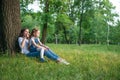 Mom and daughter are sitting near a tree Royalty Free Stock Photo