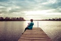 Mom and daughter are sitting on the pier at sunset Royalty Free Stock Photo