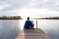 Mom and daughter are sitting on the pier at sunset Royalty Free Stock Photo