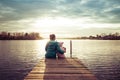 Mom and daughter are sitting on the pier at sunset Royalty Free Stock Photo