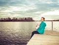 Mom and daughter are sitting on the pier at sunset Royalty Free Stock Photo