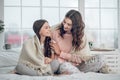 Mom and daughter sitting under blanket on bed Royalty Free Stock Photo