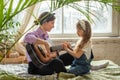 mom and daughter on the sofa, playing the guitar. a woman and a girl compose music, songs togethe Royalty Free Stock Photo