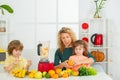 Mom daughter and son prepare a smoothie in the kitchen. Happy loving family. Vegan nutrition and a healthy lifestyle.