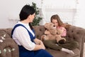 Mom and daughter spend time together, sit on the couch and chat. Leisure mothers and daughters. Sad girl hugs Teddy Vedmed and