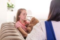 Mom and daughter spend time together, sit on the couch and chat. Leisure mothers and daughters. Sad girl hugs Teddy Vedmed and