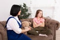 Mom and daughter spend time together, sit on the couch and chat. Leisure mothers and daughters. Sad girl hugs Teddy Vedmed and
