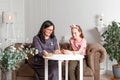 Mom and daughter spend time together, sit on the couch, chatting and playing with toy animals. Leisure mothers and daughters