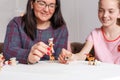 Mom and daughter spend time together, sit on the couch, chatting and playing with toy animals. Leisure mothers and daughters