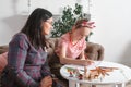 Mom and daughter spend time together, sit on the couch, talk and draw with colored pencils. Leisure mothers and daughters. Girl