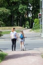 Mom and daughter stand on pedestrian crossing on red light, waiting green light Royalty Free Stock Photo