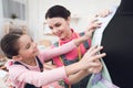 Mom and daughter try on a new dress on mannequin.