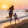 Mom and daughter walk on a seashore on a sunny evening Royalty Free Stock Photo