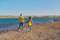 Mom and daughter walking together on the sandy beach of a resort hotel. Royalty Free Stock Photo