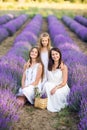 Mom and daughters in a lavender field. Summer photo in purple colors