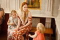 Mom with daughters sit on bench in Church Orthodox