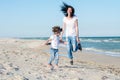 Mom and doughter on the beach, having fun together