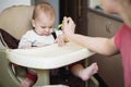 Mom feeds the baby who is naughty Royalty Free Stock Photo