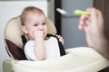 Mom feeds the baby who is naughty Royalty Free Stock Photo