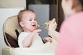 Mom feeds the baby who is naughty Royalty Free Stock Photo