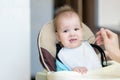 Mom feeds the baby who is naughty Royalty Free Stock Photo