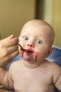 Mom feeds a child from a spoon with raspberry juice Royalty Free Stock Photo