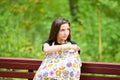 Mom feeds the newborn on the bench. covered with a diaper from prying eyes. Young woman, new mother breastfeeding and caring her Royalty Free Stock Photo