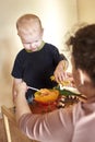 Mom feeds toy dinosaurs from a spoon Royalty Free Stock Photo