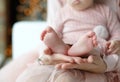 Mother holds in her palms the feet of the feet of her newborn daughter Royalty Free Stock Photo