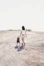 Mom and girl walk along the endless gravel road