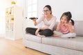 Mom with girl watching the funny TV channel Royalty Free Stock Photo