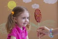 Mom gives the baby a lollipop, happy little girl eating big sugar lollipop, kid eat sweets. Beautiful little girl with Royalty Free Stock Photo