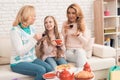 Mom, grandmother and little girl are drinking tea together, sitting at the table. Royalty Free Stock Photo