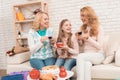 Mom, grandmother and little girl are drinking tea together, sitting at the table. Royalty Free Stock Photo