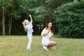 Mom has fun with her five-year-old daughter in nature, blowing soap bubbles, the girl catches them