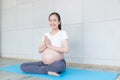 Mom is having fun doing yoga. Pregnant woman doing morning exercises at home Royalty Free Stock Photo