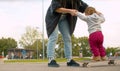 Mom helping baby trying to ride a skate