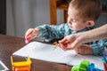 Mom is helping child to draw with pencils on paper in an album. Preschool education and development of creativity Royalty Free Stock Photo