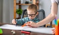 Mom is helping child to draw with pencils on paper in an album. Preschool education and development of creativity Royalty Free Stock Photo