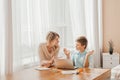 Mom helping little boy to do homework. Mother and son drawing together, mom helping with homework. Home schooling concept. Royalty Free Stock Photo