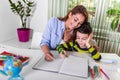 Mom helping little boy to do homework. Mother and son drawing together, mom helping with homework. Cute boy doing his school Royalty Free Stock Photo