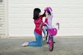 Mom helps her daughter to fasten a helmet