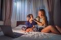 Mom helps her son to put on headphones. Boy meditates on bed using meditation app. sport, technology and healthy