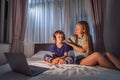 Mom helps her son to put on headphones. Boy meditates on bed using meditation app. sport, technology and healthy
