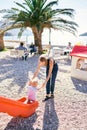 Mom helps a little boy down a slide on the beach Royalty Free Stock Photo