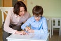 Mom helps son to do homework. teacher deals boy. Royalty Free Stock Photo